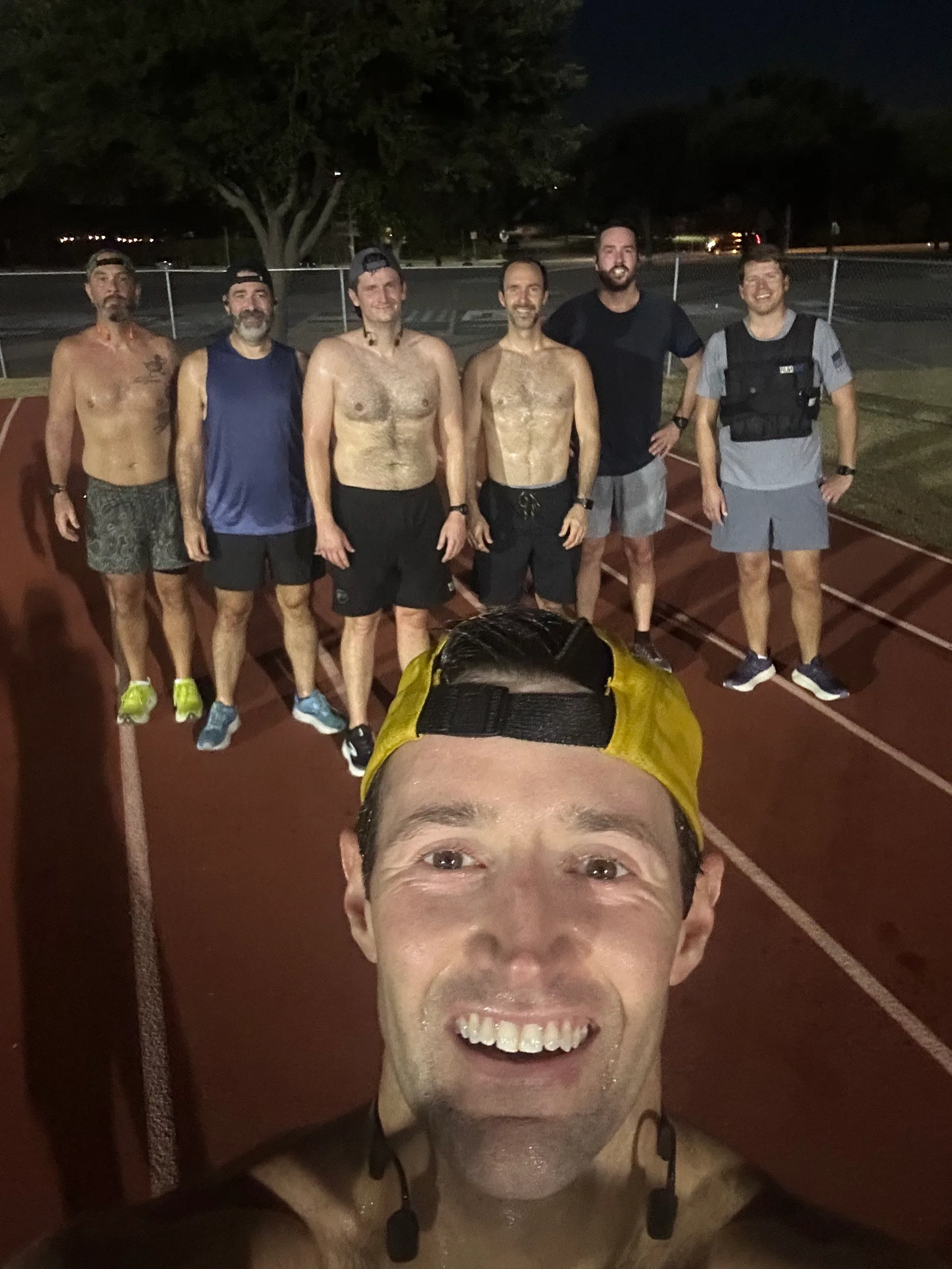 F3 Dallas group taking a selfie on a running track before sunrise