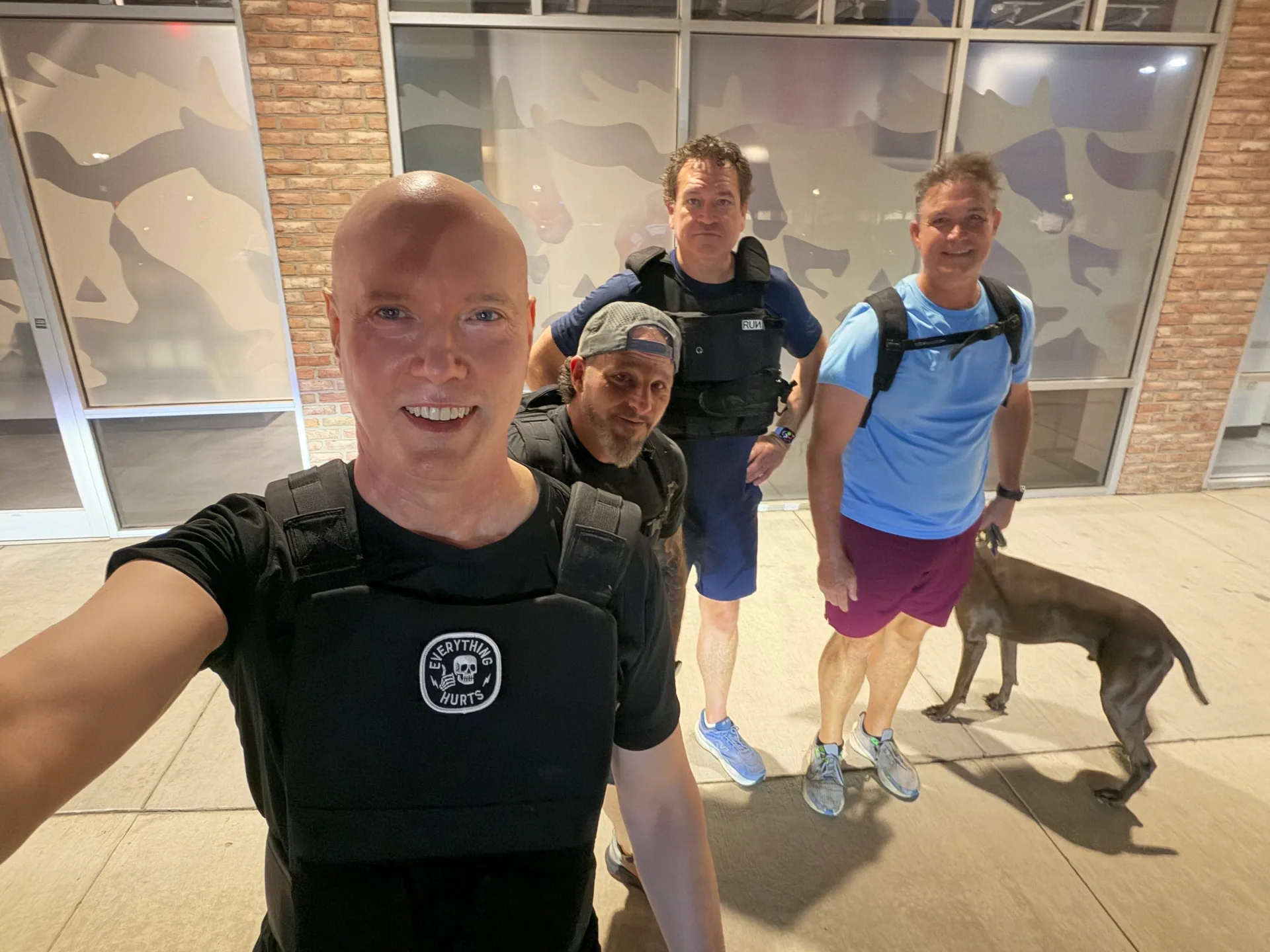 F3 Dallas members wearing weighted vests outside a storefront with a dog